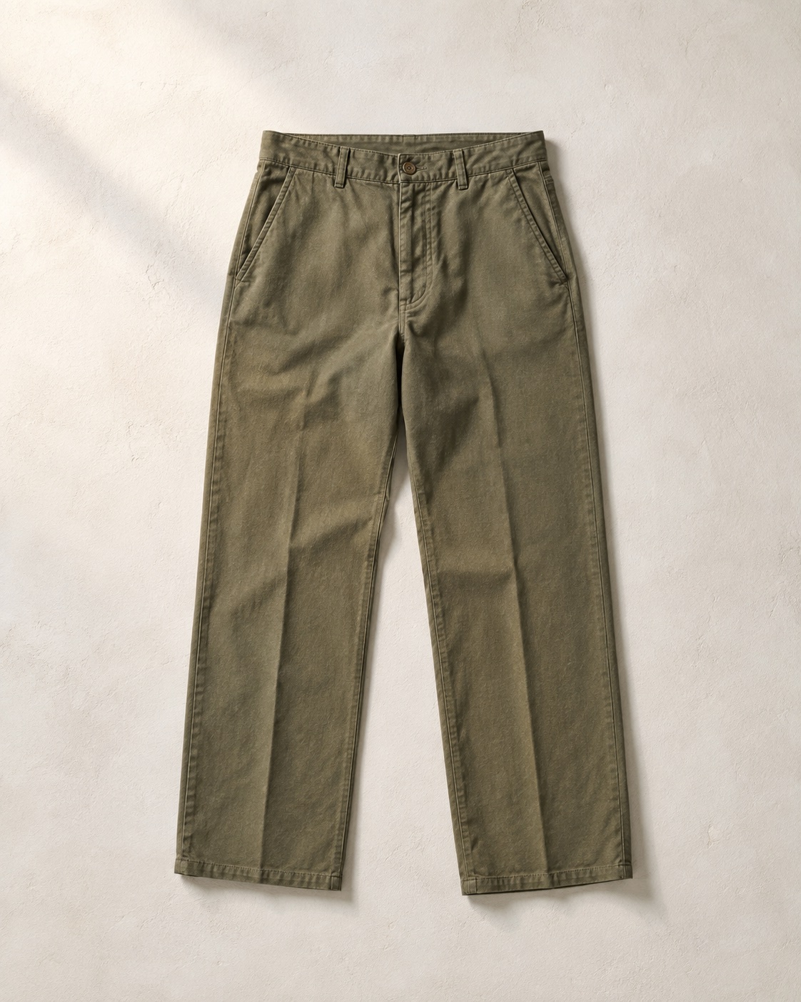 Unbranded olive hemp and cotton pants photographed flat on a warm neutral surface